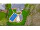 Aerial view of a backyard featuring a swimming pool, white deck with lounge furniture, and mature trees at 310 Edgewood E Pl, Anderson, IN 46011