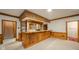Finished basement featuring a wooden bar area with stairs in the background at 310 Edgewood E Pl, Anderson, IN 46011
