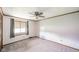 Bright carpeted bedroom featuring a ceiling fan, large window and wood trim at 310 Edgewood E Pl, Anderson, IN 46011