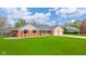 Beautiful brick home with a lush green lawn, black awnings and attached two-car garage at 310 Edgewood E Pl, Anderson, IN 46011