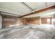 Spacious garage features wood paneling, a concrete floor, overhead lighting and an automatic door opener at 310 Edgewood E Pl, Anderson, IN 46011