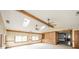 Open-concept living room with wooden beams, skylights, brick accent wall, built-ins and multiple windows at 310 Edgewood E Pl, Anderson, IN 46011