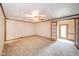 Spacious living room featuring a ceiling fan, neutral carpet, and a glass paned door at 310 Edgewood E Pl, Anderson, IN 46011
