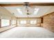 Bright living room featuring wooden beams, skylights, a brick wall, and large windows with views at 310 Edgewood E Pl, Anderson, IN 46011