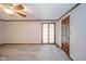 A living room featuring neutral carpet, a ceiling fan, and a door to the outside at 310 Edgewood E Pl, Anderson, IN 46011