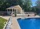 An in-ground swimming pool with adjacent pergola-covered deck and hot tub at 310 Edgewood E Pl, Anderson, IN 46011