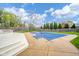 Backyard pool with cover, deck and lounge chairs, and mature landscaping at 310 Edgewood E Pl, Anderson, IN 46011