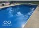 Clear in-ground pool surrounded by concrete patio with view of lounge chairs at 310 Edgewood E Pl, Anderson, IN 46011