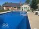 Beautiful in-ground swimming pool with a house and deck in the background at 310 Edgewood E Pl, Anderson, IN 46011