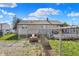 Fenced backyard features gravel area, lawn, and a small deck, with a clear blue sky overhead at 3104 Poplar St, Anderson, IN 46012