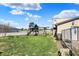 Backyard features a playground with a slide and swingset, green grass and adjacent building at 3104 Poplar St, Anderson, IN 46012