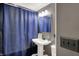 Bathroom features a pedestal sink, mirror, and blue shower curtain at 3104 Poplar St, Anderson, IN 46012