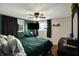 Cozy bedroom with dark curtains, green accents, and mounted television at 3104 Poplar St, Anderson, IN 46012