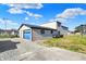 Exterior view of the garage featuring a bright blue door and ample parking on gravel area at 3104 Poplar St, Anderson, IN 46012