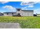 Exterior view of garage featuring grassy yard, gravel parking, and vintage spools at 3104 Poplar St, Anderson, IN 46012
