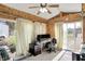 Bright sunroom with natural wood walls, ceiling fan, and large windows at 3104 Poplar St, Anderson, IN 46012