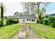 View of the home's backyard showcasing the expansive yard with its mature trees and partially paved driveway at 3109 Forest Manor Ave, Indianapolis, IN 46218