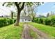 A view of the rear exterior with a spacious yard, tree, and convenient driveway access at 3109 Forest Manor Ave, Indianapolis, IN 46218