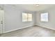 Bright and airy empty room featuring neutral walls, modern vinyl floors, and two windows at 3109 Forest Manor Ave, Indianapolis, IN 46218