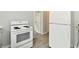 Open kitchen showcases white appliances and clear view to the hallway and entryway at 3109 Forest Manor Ave, Indianapolis, IN 46218