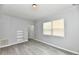Bright living room featuring modern vinyl flooring, fresh paint, and large window for natural light at 3109 Forest Manor Ave, Indianapolis, IN 46218