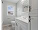 Bathroom featuring a vanity, toilet, tub, and a bright window at 3421 Arthington Blvd, Indianapolis, IN 46218