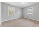 Bedroom featuring neutral carpet, gray walls, and two windows at 3421 Arthington Blvd, Indianapolis, IN 46218