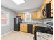 Bright kitchen with light wood cabinets, stone-look counters, and black appliances at 3421 Arthington Blvd, Indianapolis, IN 46218