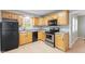 Efficient kitchen featuring wooden cabinets, black appliances, and tiled flooring at 3421 Arthington Blvd, Indianapolis, IN 46218