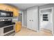 Kitchen with wood cabinets, stainless steel range, and view of hallways at 3421 Arthington Blvd, Indianapolis, IN 46218