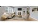 Stylishly furnished living room features built-in shelving, a fireplace, and large windows for ample light at 3421 Arthington Blvd, Indianapolis, IN 46218