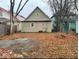 Back of property featuring an detached garage, offering parking and storage, set against a leaf-covered yard at 438 N Keystone Ave, Indianapolis, IN 46201