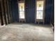 An unfinished room in need of renovation showcases raw framing and weathered hardwood flooring, awaiting transformation at 438 N Keystone Ave, Indianapolis, IN 46201