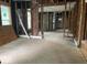 A vacant living room space reveals its framing and rough hardwood floors, hinting at the potential for custom renovation at 438 N Keystone Ave, Indianapolis, IN 46201