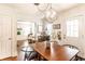 This dining room features a wood table, modern chandelier, and an open view to the living room at 4406 Carrollton Ave, Indianapolis, IN 46205