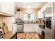 Charming kitchen features white cabinets, stainless steel appliances, decorative backsplash, and a cozy floral rug at 4406 Carrollton Ave, Indianapolis, IN 46205