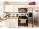 Functional kitchen features white cabinets, stainless steel appliances and efficient layout at 4406 Carrollton Ave, Indianapolis, IN 46205