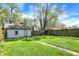 Spacious backyard with lush green grass, a fenced perimeter, and a detached garage at 4623 Evanston Ave, Indianapolis, IN 46205