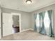 A bright bedroom with neutral carpet and beautiful curtains covering the windows at 4623 Evanston Ave, Indianapolis, IN 46205