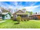 Inviting home with a screened porch, quaint landscaping, and a vibrant green lawn under a bright sky at 4623 Evanston Ave, Indianapolis, IN 46205