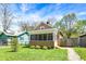 A charming home boasts a screened-in porch and a well-manicured front yard with lush green grass at 4623 Evanston Ave, Indianapolis, IN 46205