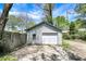 Detached garage with a white door and siding, situated in a backyard with a partial fence and concrete driveway at 4623 Evanston Ave, Indianapolis, IN 46205