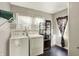 Functional laundry room with white washer, dryer and dark wood floors at 4623 Evanston Ave, Indianapolis, IN 46205