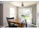 Bright dining area with a wooden table, bench seating, and sliding doors to the backyard at 4625 Elkhorn Ct, Noblesville, IN 46062