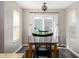 Dining area featuring wood-look floors, a wooden table with bench seating, and natural light from windows at 4625 Elkhorn Ct, Noblesville, IN 46062