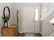 Bright foyer showcasing the front door with sidelight, wood-look floors, a mirror and coat rack at 4625 Elkhorn Ct, Noblesville, IN 46062