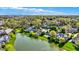 Aerial view of homes nestled in a lush, green landscape with a serene lake and a view of the city skyline at 4726 Ellery Ln, Indianapolis, IN 46250