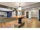 Open basement space with stone bar, hardwood floors, brick design, and archways at 4726 Ellery Ln, Indianapolis, IN 46250