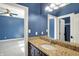 Elegant bathroom vanity with granite countertop and a view into a blue accent-walled room at 4726 Ellery Ln, Indianapolis, IN 46250