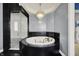 Luxurious bathroom showcases a large soaking tub, a sleek glass shower, and an elegant chandelier at 4726 Ellery Ln, Indianapolis, IN 46250